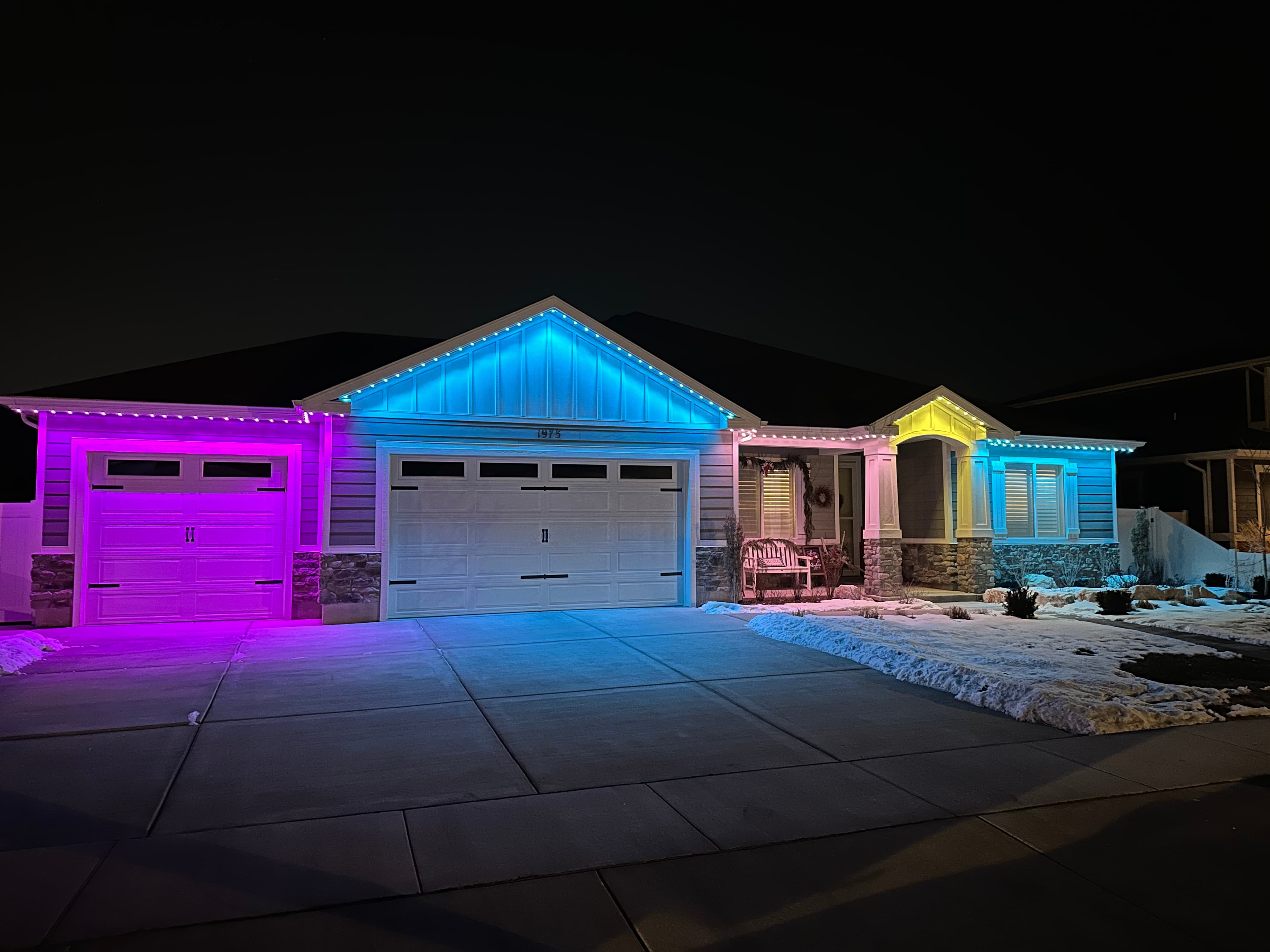 A roofline lit in purple, blue and warm yellow