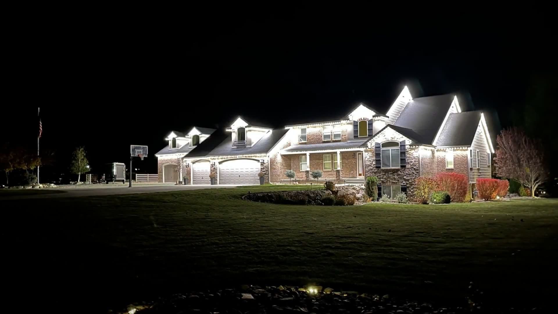 A home's roofline lighting coming on at night and changing color